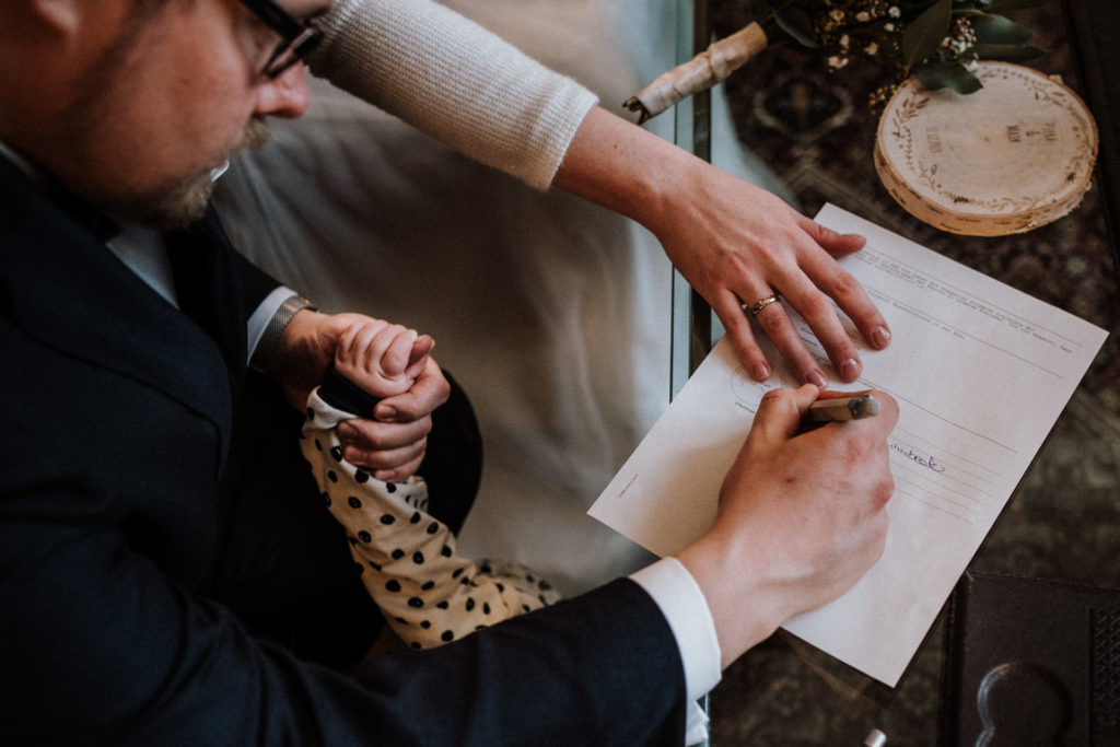 paar unterschreibt mit kinderhand bei standesamtlicher trauung in bielefeld