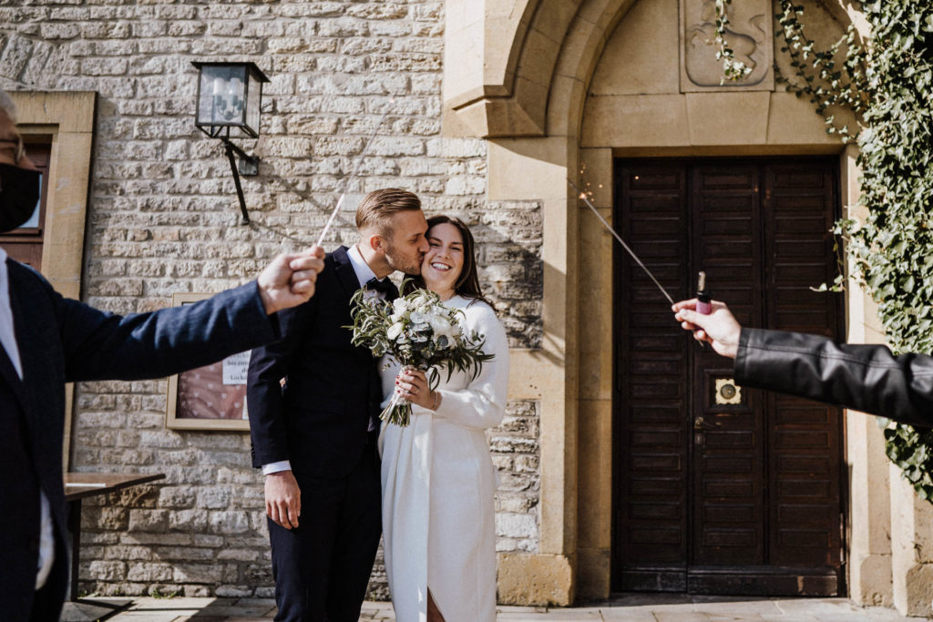 bräutigam küsst braut nach hochzeit an sparrenburg